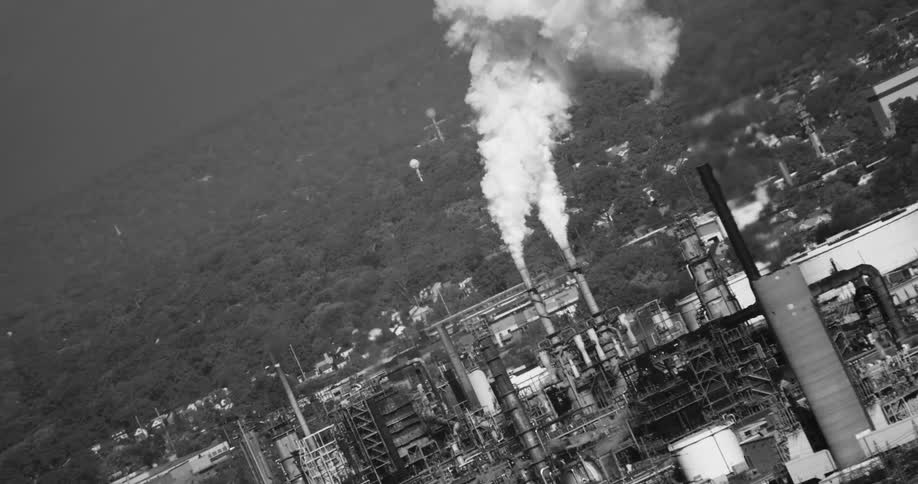 Factories releasing pollutants and trees in the background