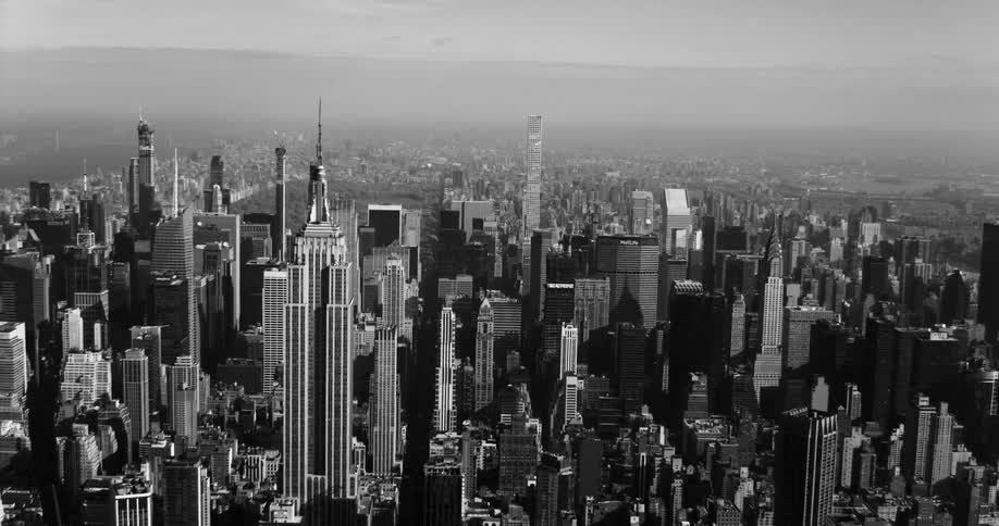 Empire state building towers over nearby skyscrapers as fog obscures edges of city