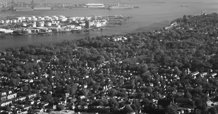 Aerial view of an urban city with residential neighborhoods and a seaside metropolis on the horizon