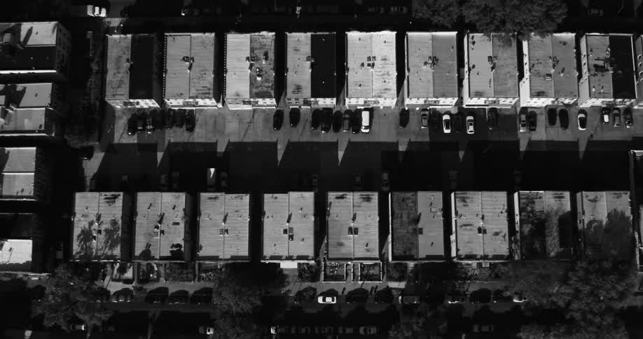 Vehicles park near apartments and travel along nearby streets