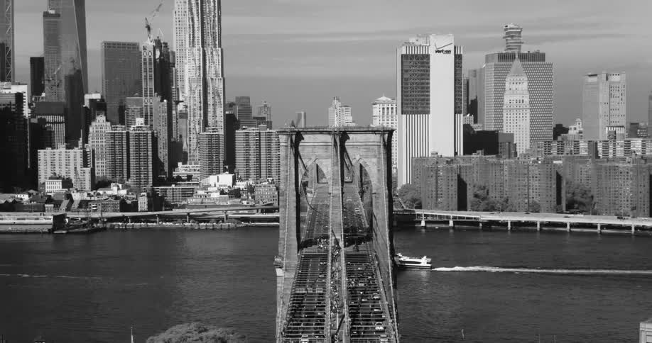 Traffic moves across a bridge leading into and out of a dense city