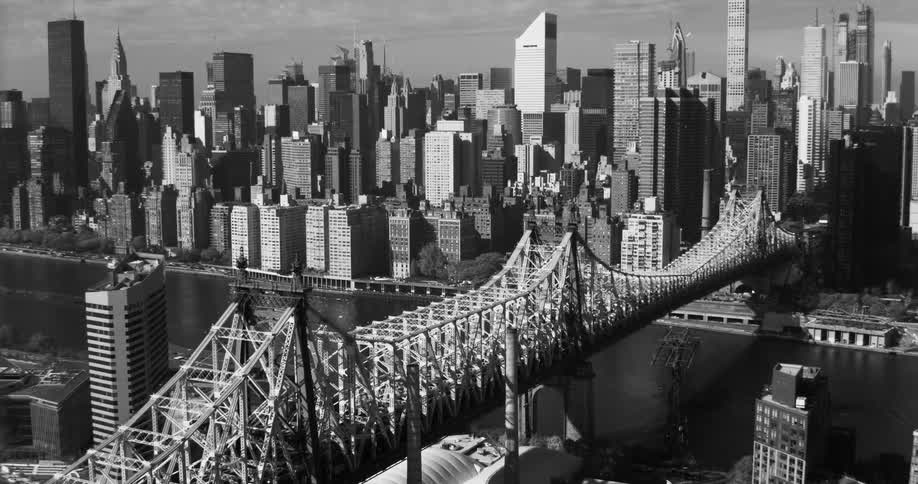 Manhattans skyline in black and white including a bridge and river