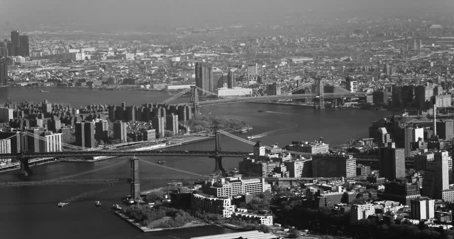 An aerial black and white footage of new york city bridges over the river