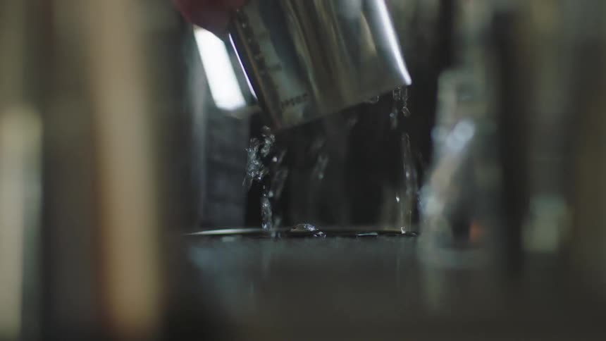 A man dips the cup into the water