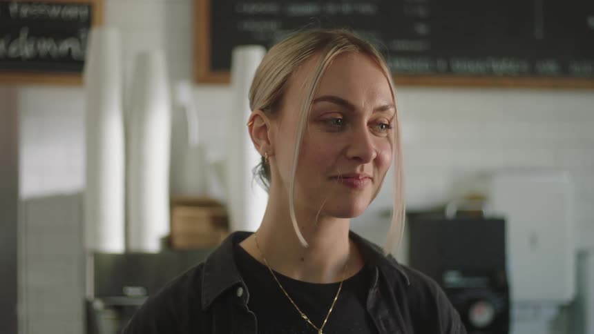 A female employee serves a customer in a restaurant