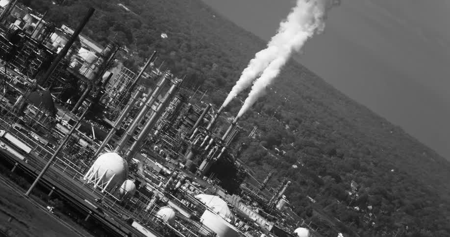 Two industrial towers releasing a lot of white smoke upwards in black and white tones