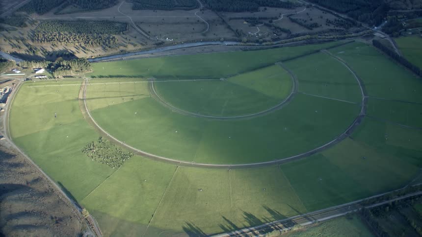 Aerial panorama of greenish fields with patterns from irrigators