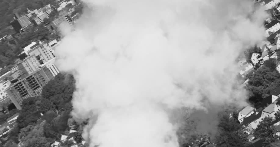 An aerial view showed a white cloud flying over a city in black and white tones