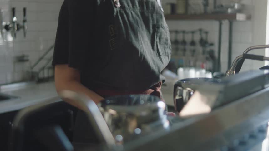 A female employee at a restaurant cleans cookware