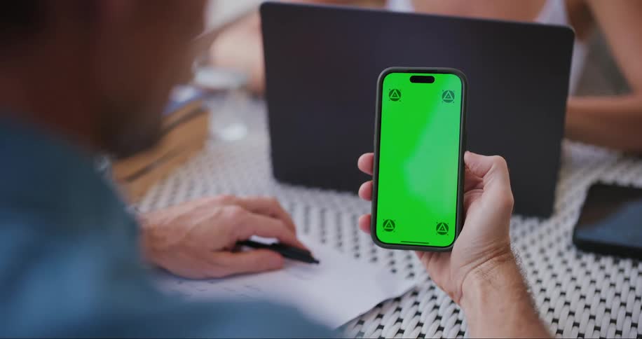 A man and woman are using a laptop and cell phone