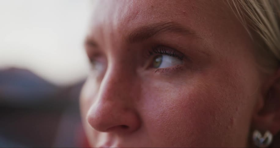 A woman blinks her eyes and looks up