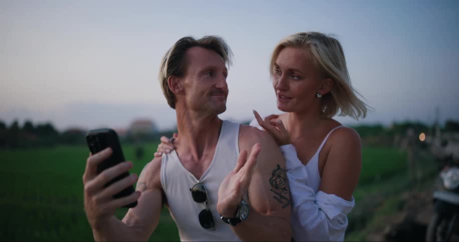 Couple sitting hugging on the edge of a field talking