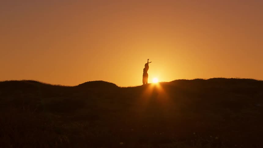 A woman is doing tai chi on the hill