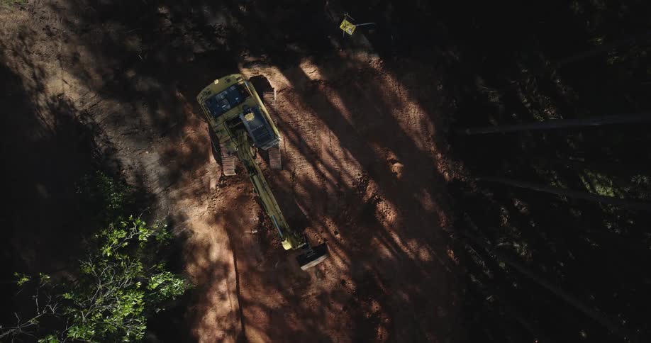 Aerial view on an excavator working on a soil in a forest