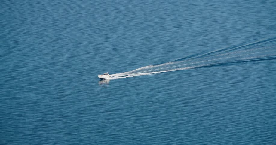 A boat travels in the blue waters