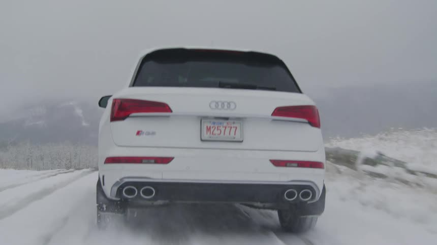 A car driving on a snow covered storm during a blizzard