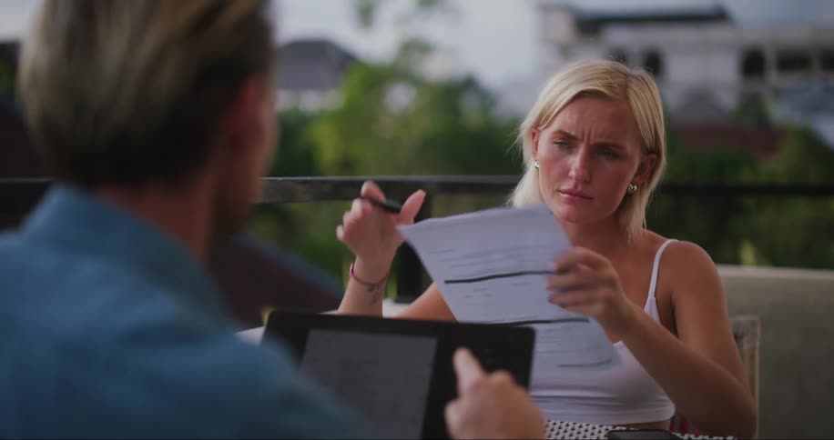A woman listens to a man talk while holding paperwork