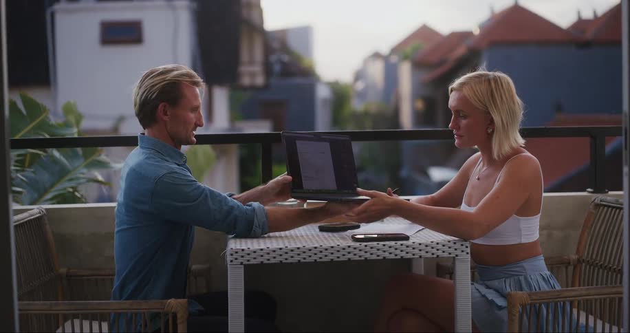 A man shows a woman his laptop