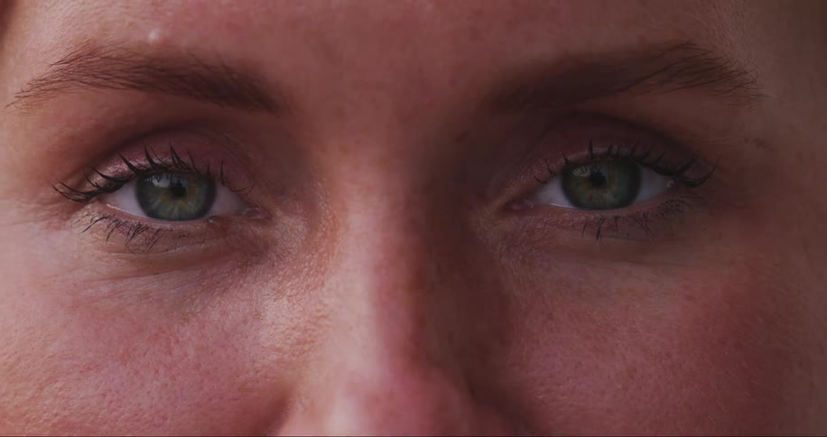 Extreme closeup of a womans clear eyes opening