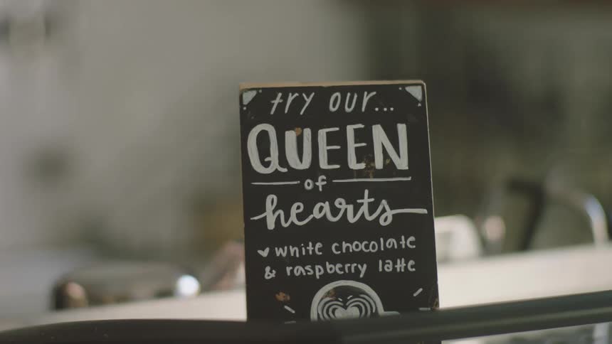 Person placing a small sign on a counter in an establishment