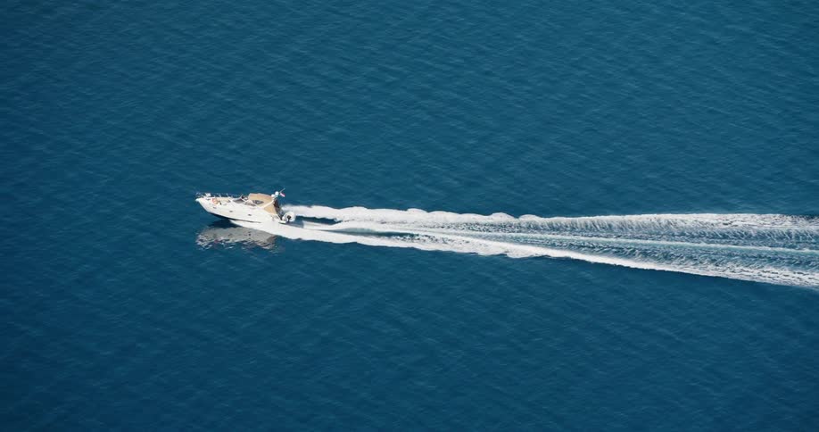 A small boat creates a large wake on water