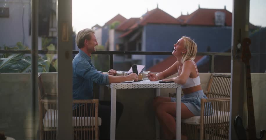 A man and a woman are sitting at a table and they are talking and smiling
