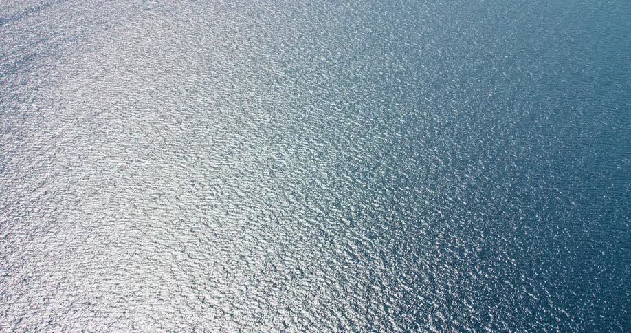 Aerial view open water ocean ripples light reflection