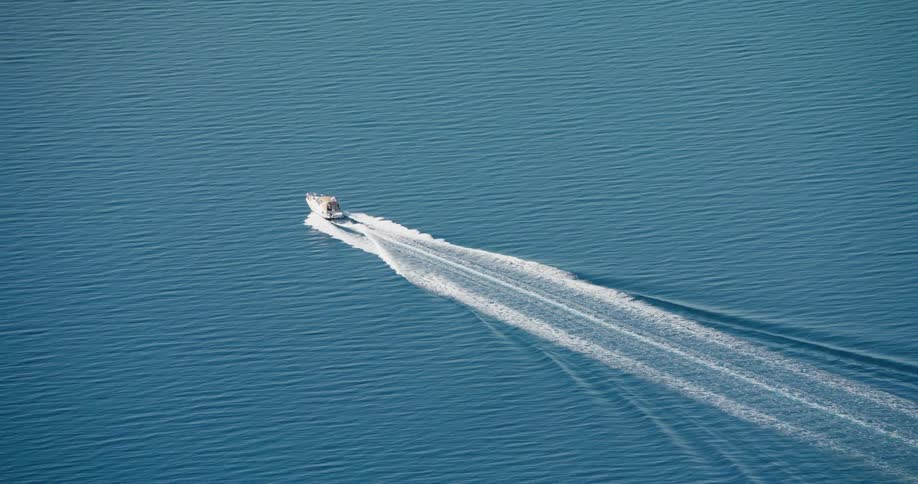 A boat moving on the surface of a body of water creating a vshaped wake