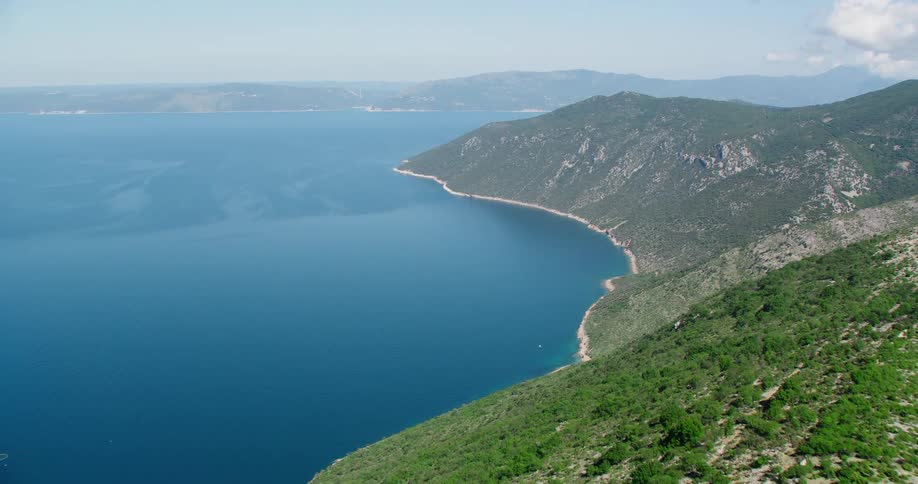 High mountains give way to beach areas on a coast