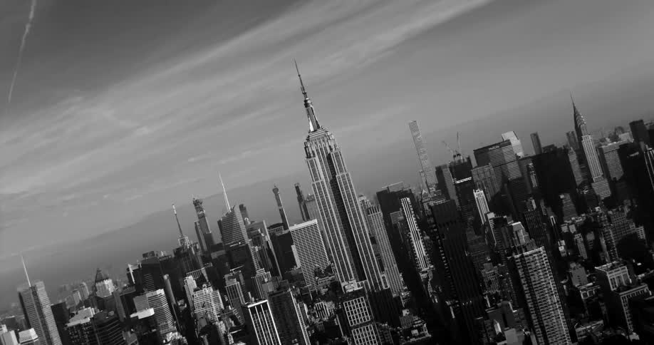 The empire state building sits in the middle of the skyscrapers