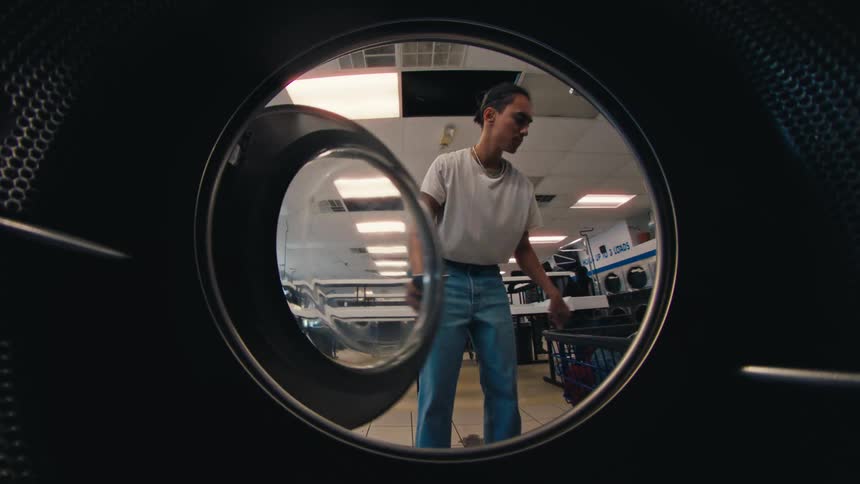 A man puts his laundry in the washing machine