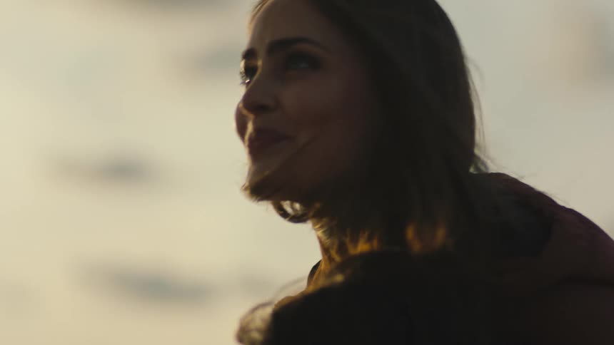 Woman smiles while spending time outdoors on a windy day with someone