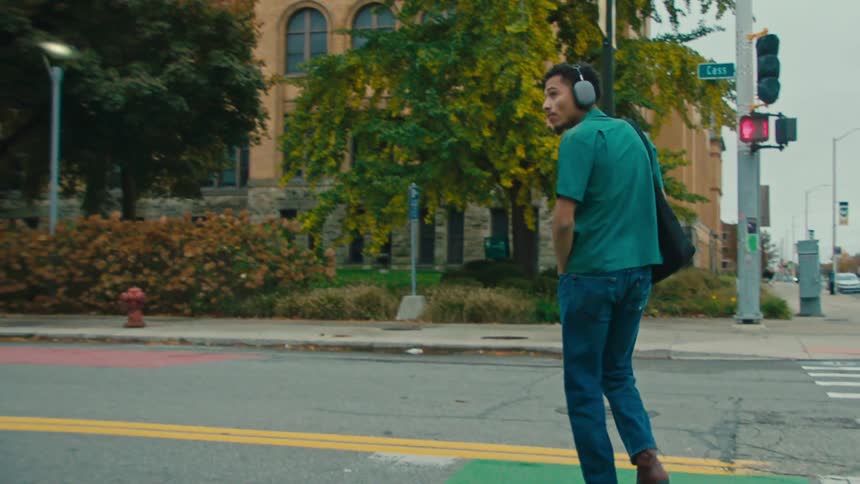 Man with headphones crossing the street in a metropolis