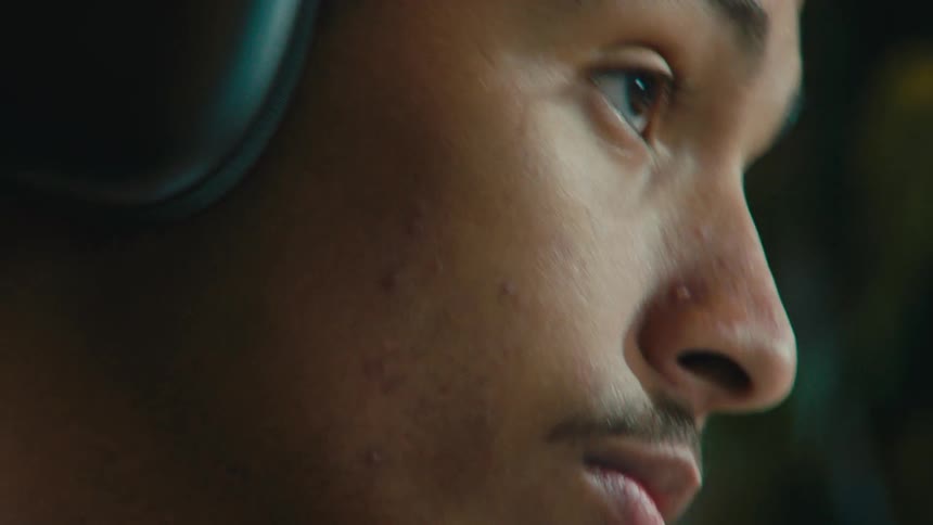 Side portrait of a concentrated young man using headphones