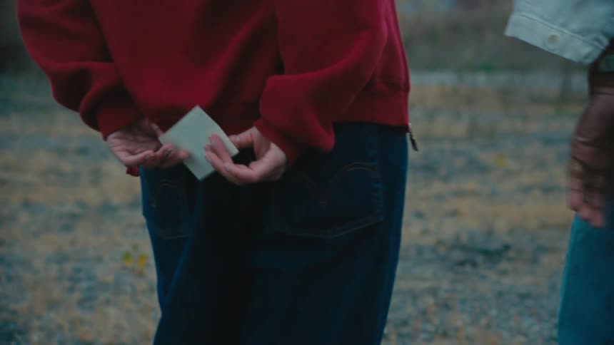 Friends pass a note behind their backs