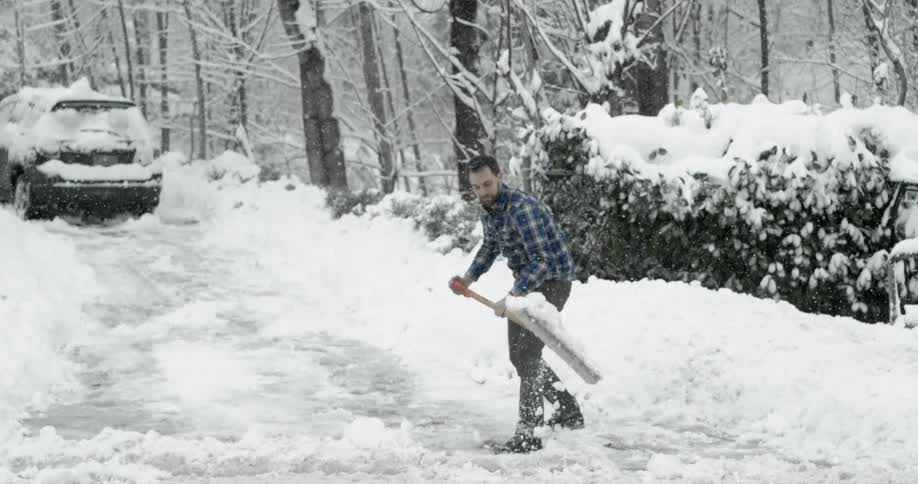 Man shoveling snow from a driveway