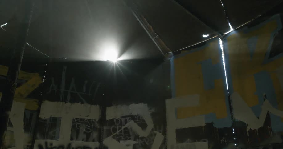 A light is shining over a wall in this dark area