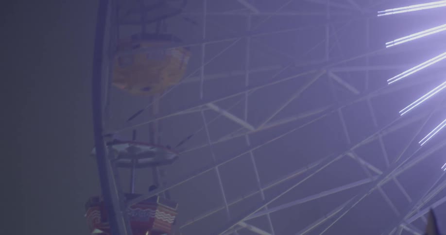 Lights shine on the spokes of a ferris wheel