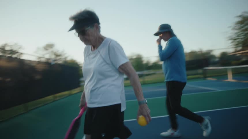 Four retired people on a court playing pickleball together