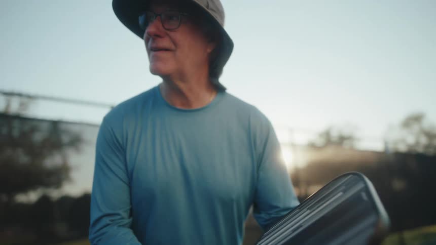 An elderly man in ready position as he plays pickleball