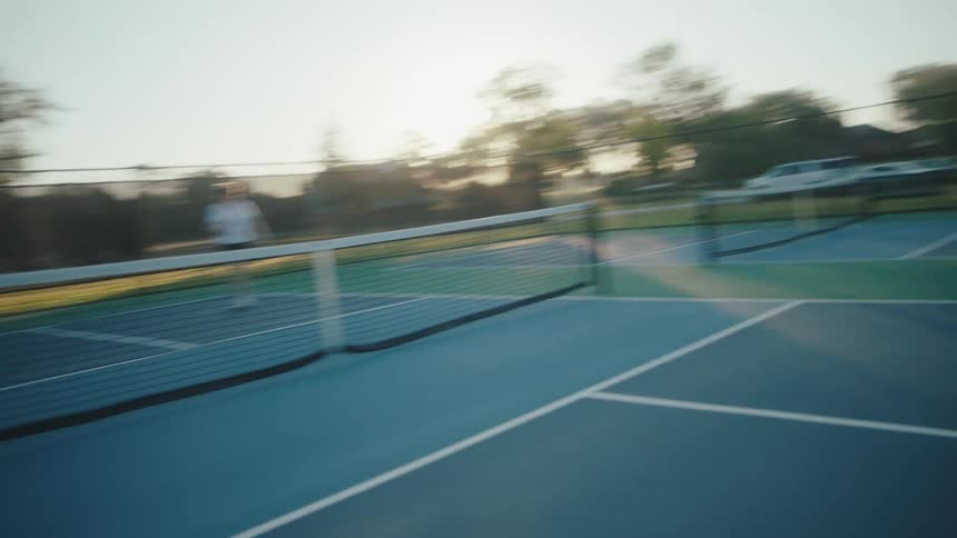People are playing pairs pickleball on the court