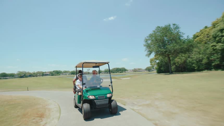 People in a golf cart enjoying a ride on a course