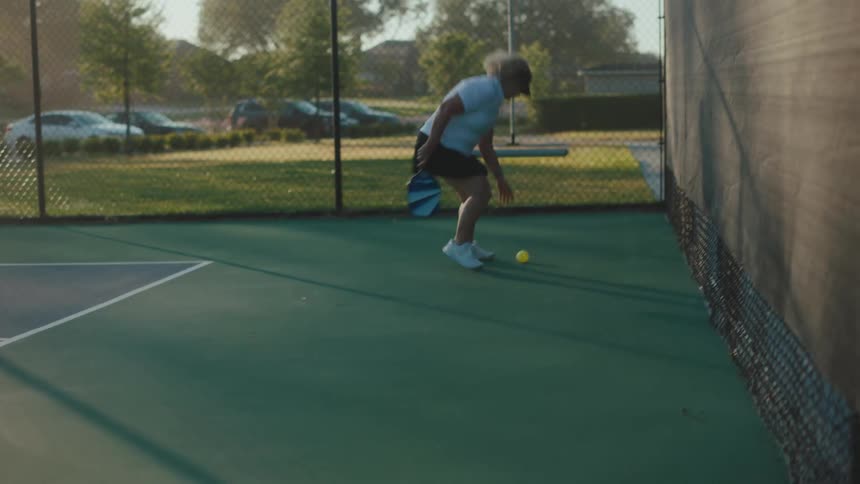 A woman chases after the pickleball during a game
