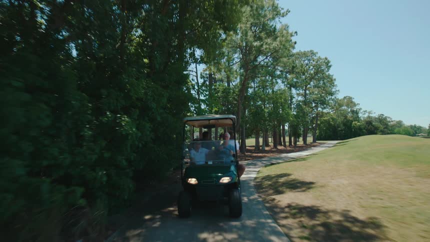 Moving golf cart with four people in a natural environment