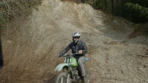 Man riding a dirt bike on dirt road