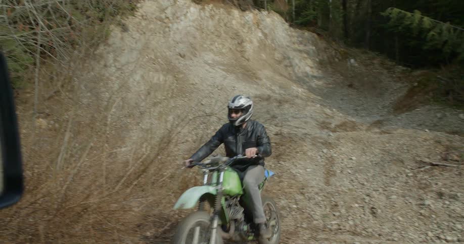 Man riding a dirt bike on dirt road