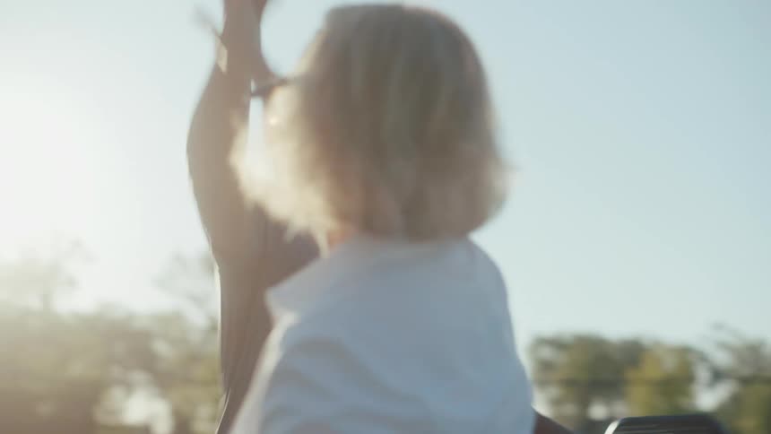 A man and a woman high five over a tennis net