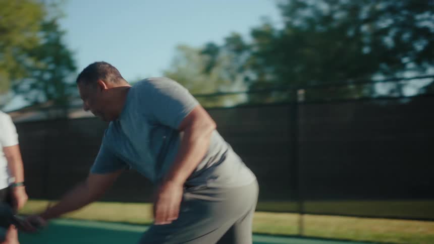 Concentrated man next to a woman on a court playing pickleball