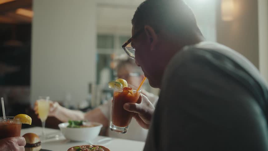 Man sitting at a restaurant table drinking a blood mary