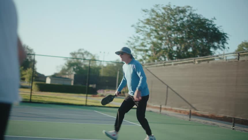 Elderly people playing a game of pickleball together